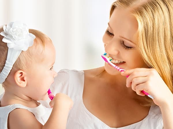 baby girl and mom brushing teeth part of dental hygiene renton wa